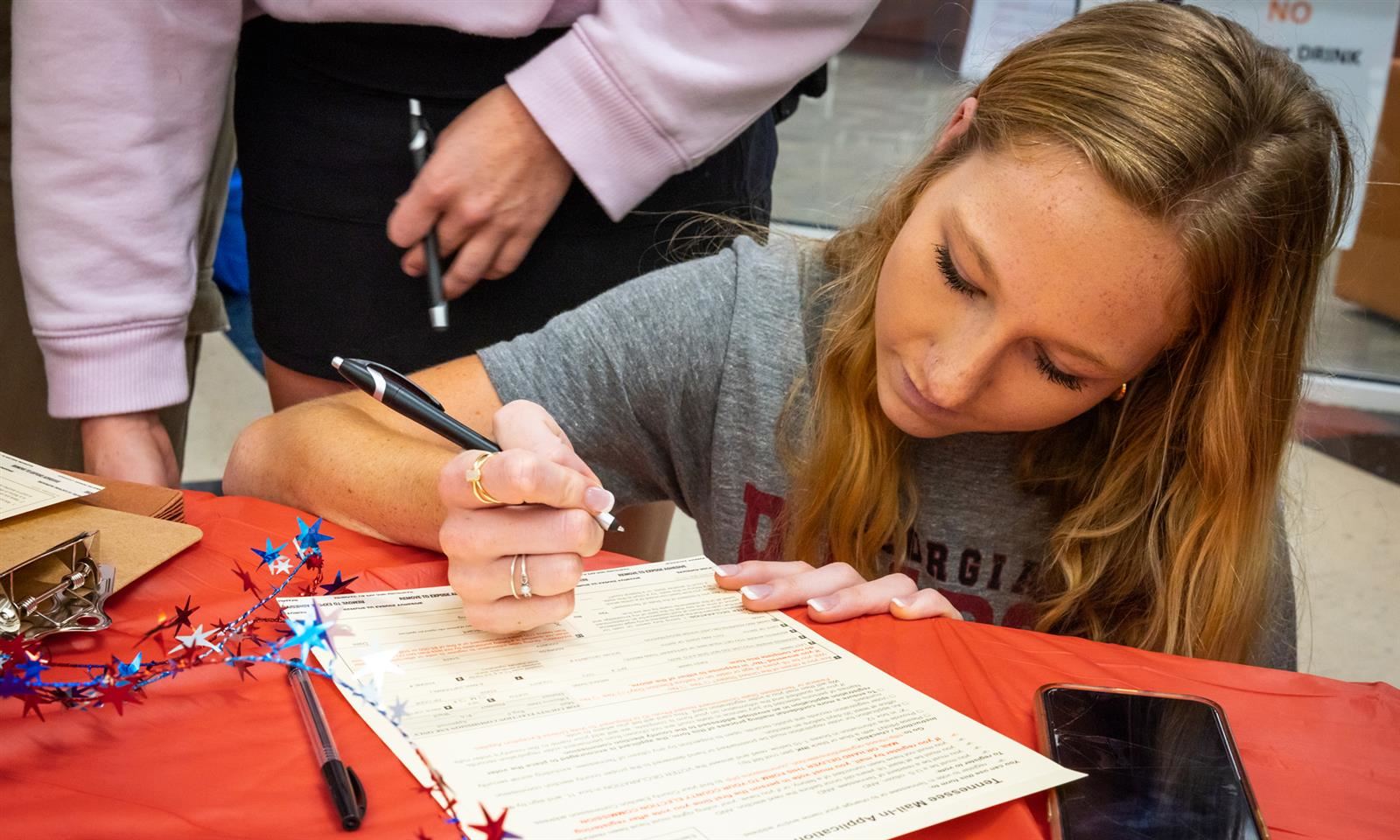 A girl fills out a voter registration form
